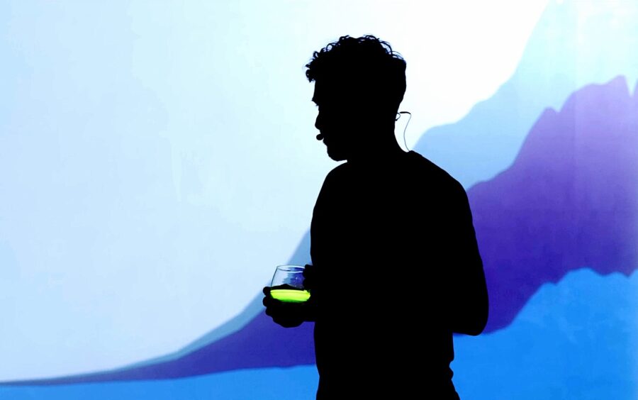 Jesse Freeston at the Porte Parole Pitch, in silhouette in front of a graph, with a cup of Atomic Tea